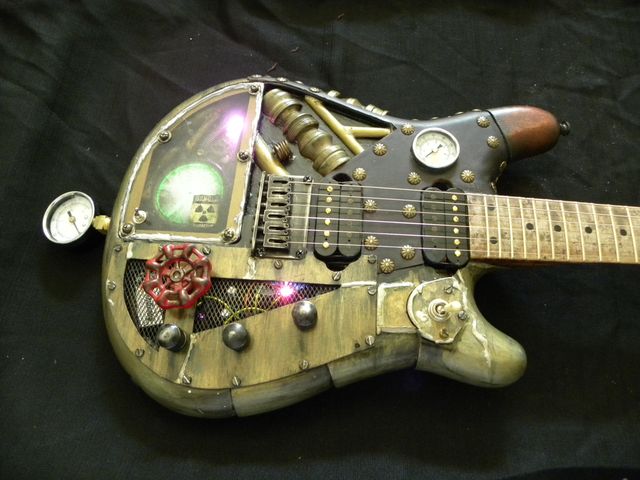 Close-up of a Gelvin steampunk custom guitar with brass gauges and valves