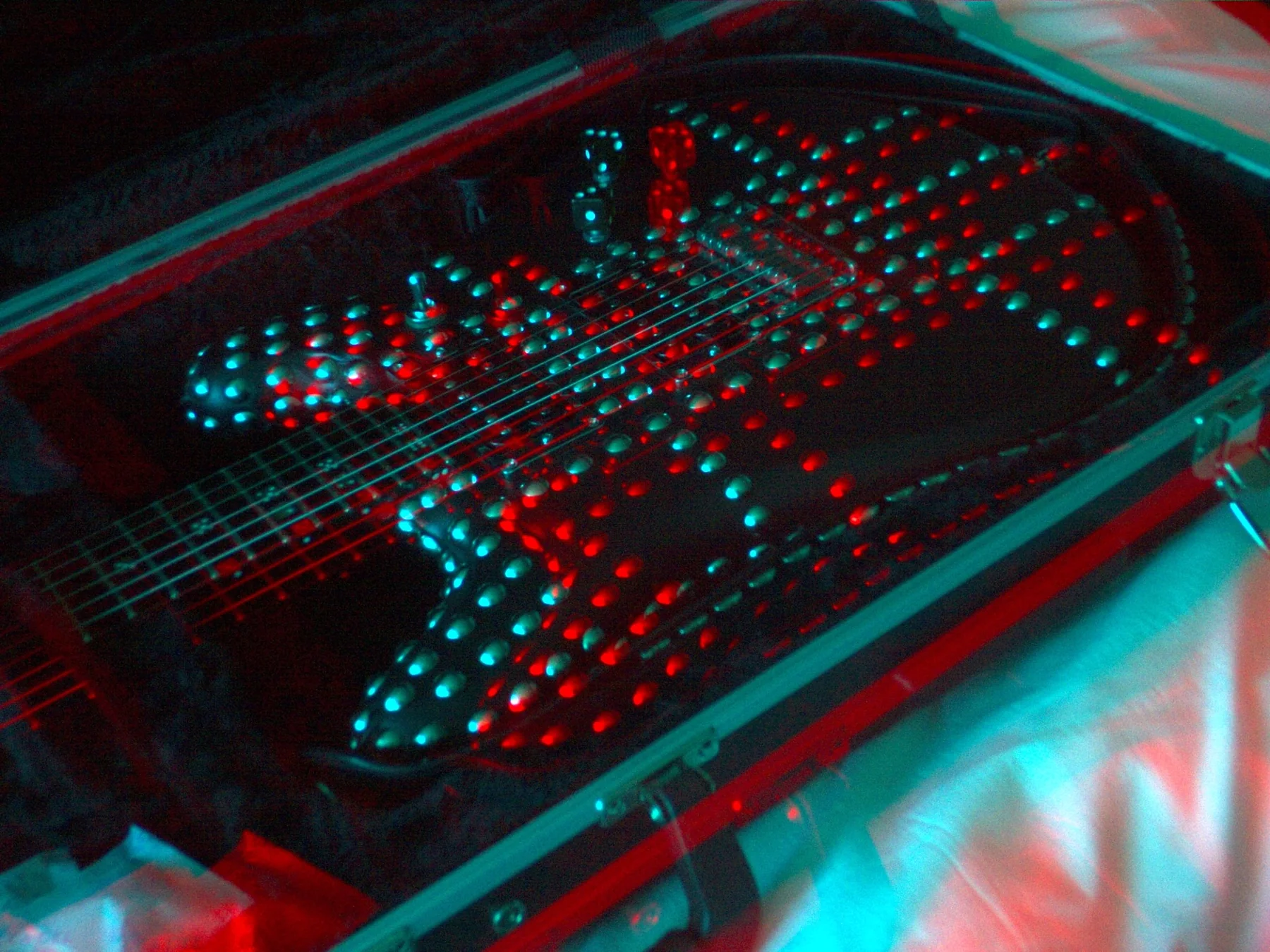 Close red and cyan 3D photograph of Andrew Dice Clay’s leather wrapped guitar