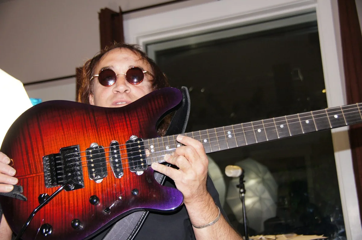 Jamie Glaser holding the red and purple Gelvin JG 2.0 close to the camera