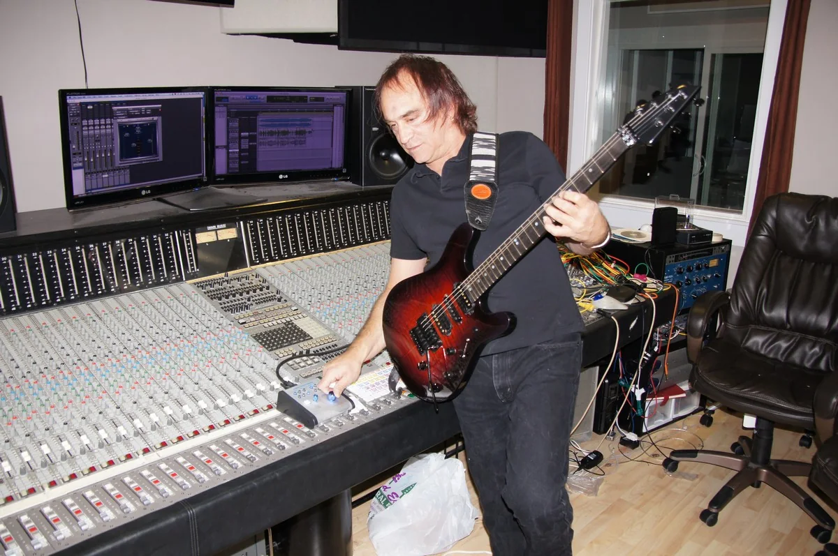 Jamie Glaser playing the Gelvin JG 2.0 beside a studio mixing console