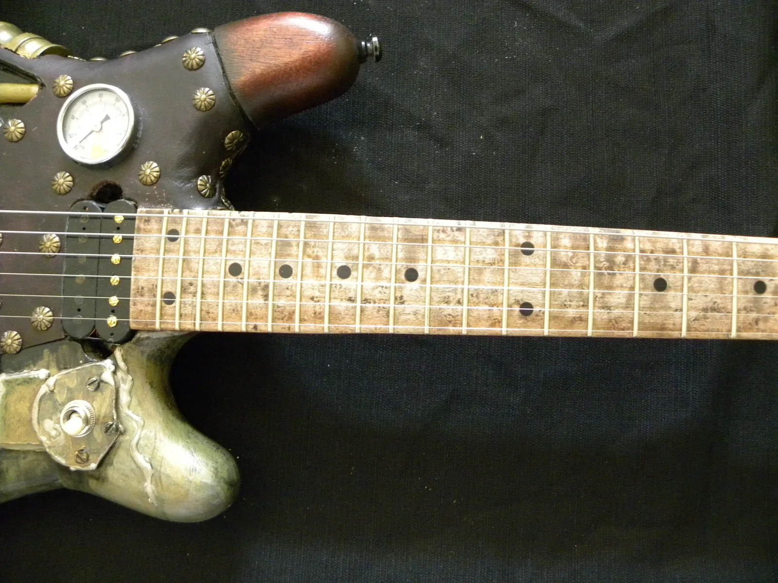 Aged birds-eye maple fretboard on the steampunk guitar