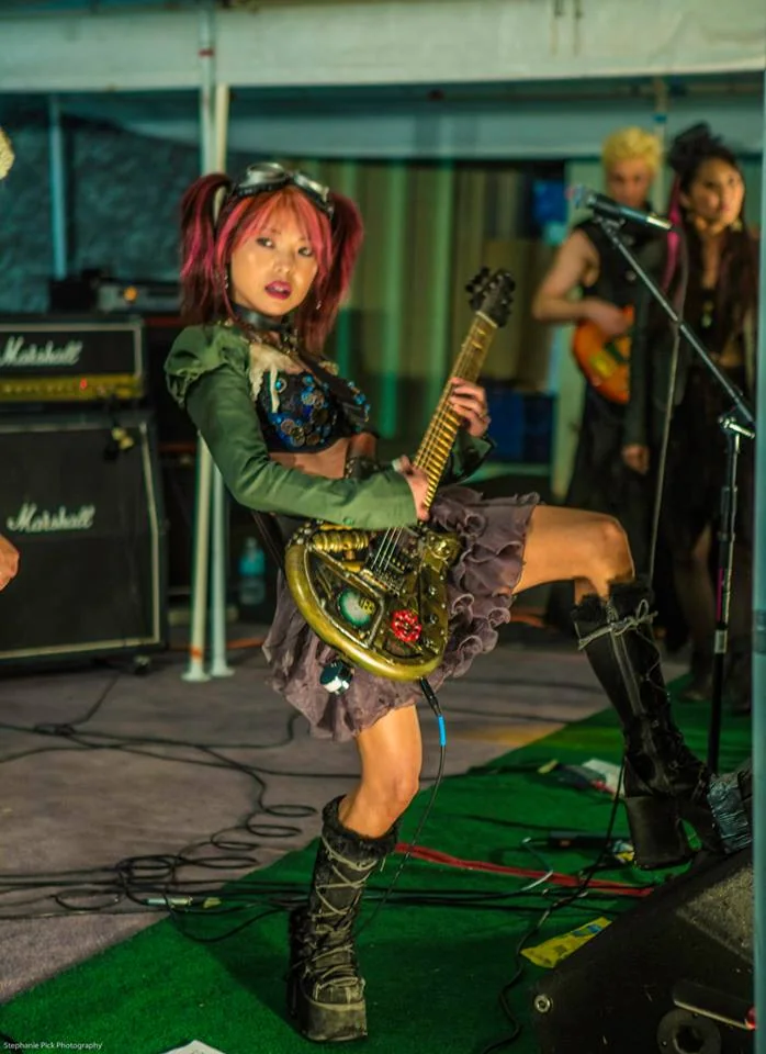 Rayko Dig performing with the steampunk guitar during a live show